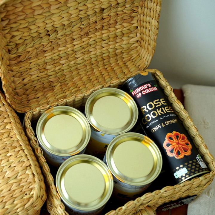 Onam Gift Basket with cans and a box of Rose Cookies on a light background